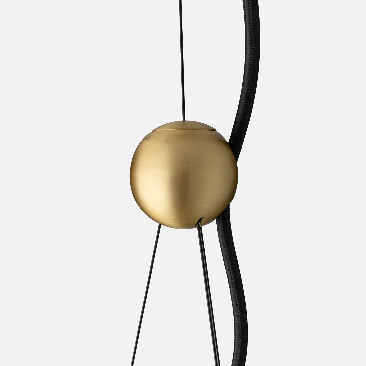 Close-up of Alfred Pendant showing natural brass counterweight and braided black cloth cord against a light gray background