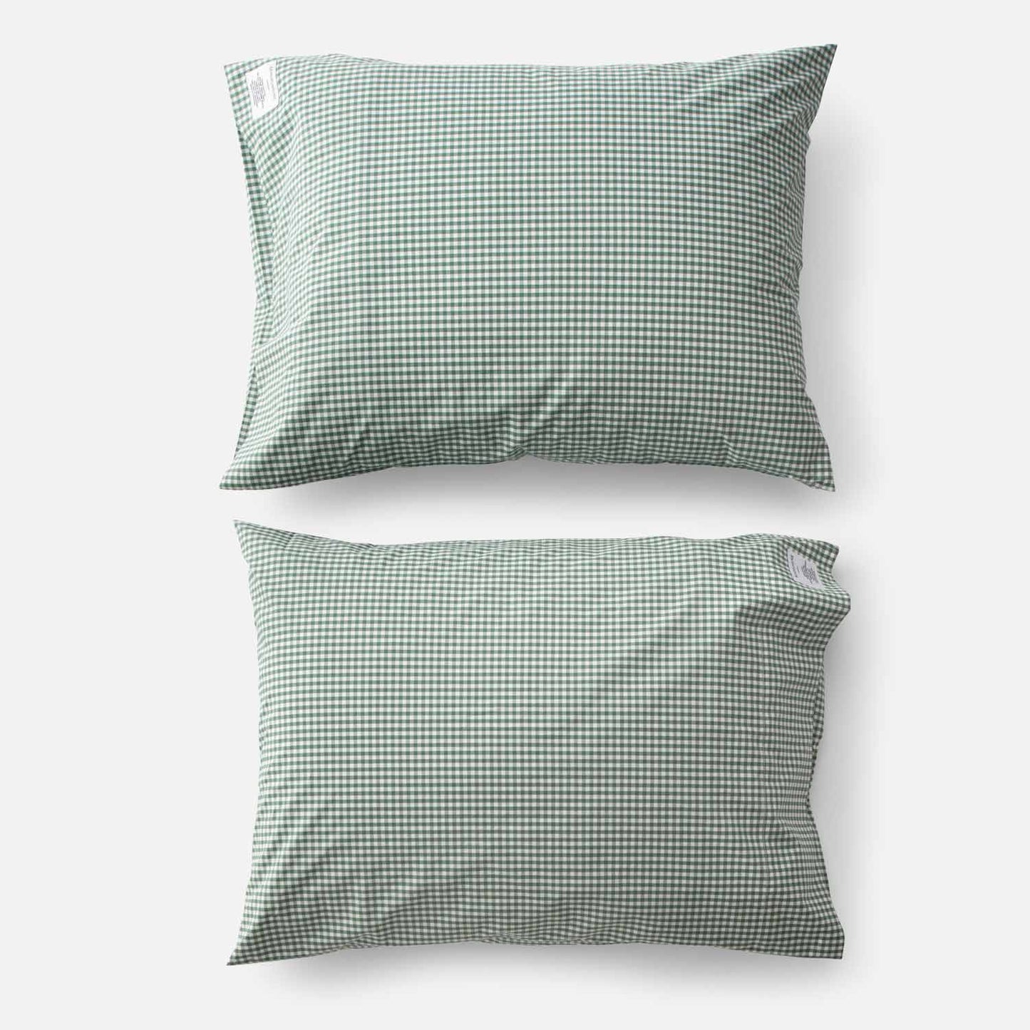 Top-down view of two Gingham Percale pillowcases (set of 2) showcasing juniper green gingham check pattern on white background